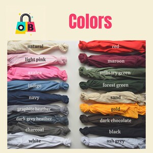 May include: A color chart showing 16 different colors of fabric swatches. The colors are: natural, light pink, azalea, indigo, navy, graphite heather, dark grey heather, charcoal, white, red, maroon, military green, forest green, sand, gold, dark chocolate, black, and ash grey.