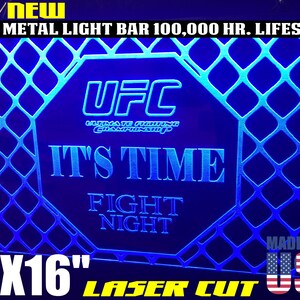 May include: A blue and white 12x16 inch laser cut sign with the UFC logo and the text "It's Time Fight Night". The sign is made in the USA.