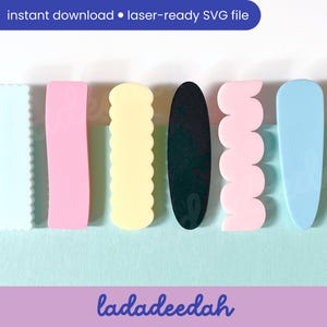 May include: Six different coloured hair clips, including light blue, pink, yellow, black, and two shades of pink. The clips are all different shapes, including a scalloped edge, a rounded rectangle, and a wavy edge.