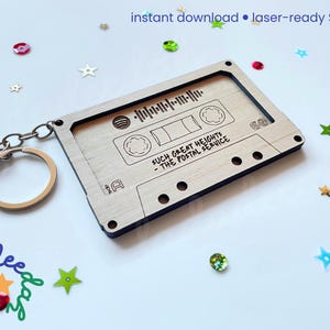 May include: A wooden cassette tape keychain with engraved details and a silver keyring. The keychain features the text "SUCH GREAT HEIGHTS - THE POSTAL SERVICE" and a soundwave graphic. The words "instant download &bull; laser-ready SVG file" are at the top.