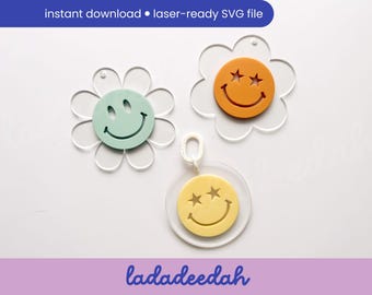 May include: Three acrylic smiley face charms in flower and circle shapes. One is mint green, one is orange, and one is yellow. Each has a smiling face design. The text "instant download • laser-ready SVG file" is at the top.