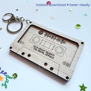 May include: A wooden cassette tape keychain with a silver keyring. The cassette design includes the text "SUCH GREAT HEIGHTS - THE POSTAL SERVICE" and a sound wave graphic. The keychain is laser-ready and an instant download.