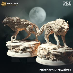 May include: Two detailed, off-white sculptures of Northern Direwolves, each posed on a rocky base with intricate details. The background features a full moon and a dark, gradient backdrop. The sculptures are labeled as "PRE SUPPORTED".