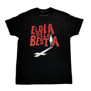 Puede incluir: Camiseta negra con un estampado gráfico rojo que dice "El Dia de la Bestia".