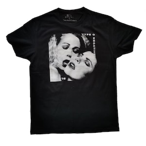 Puede incluir: Camiseta negra con una imagen en blanco y gris de dos caras de mujeres. El texto "Type O Negative" está impreso en blanco en la camiseta.