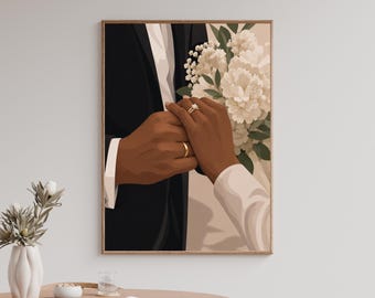 Può includere: Una stampa artistica da parete incorniciata che raffigura due mani unite, una con una fede nuziale in oro e l'altra con una fede in oro e un anello con diamante a taglio quadrato. Un bouquet di fiori bianchi è tenuto sullo sfondo, vicino a una giacca nera.