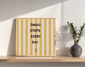 Può includere: Un quadro quadrato incorniciato con strisce verticali gialle e bianche. Il testo "SMALL STEPS EVERY DAY" è stampato in lettere maiuscole marrone scuro al centro, seguito da una piccola emoticon sorridente nella parte inferiore.
