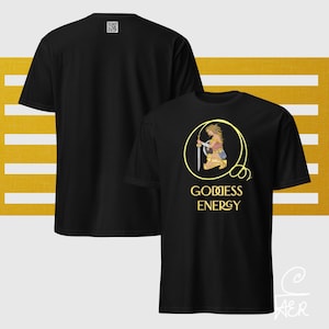 May include: Black t-shirt featuring a gold illustration of a woman with a sword inside a circle, with the words "GODDESS ENERGY" below. The back of the shirt has a small QR code. The shirt is displayed against a yellow and white striped background.