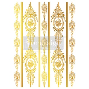 May include: A gold-colored decorative transfer sheet featuring repeating vertical patterns of floral bouquets in oval frames and thin stripes. The text "re-design with prima" is printed in white across the center of the sheet.