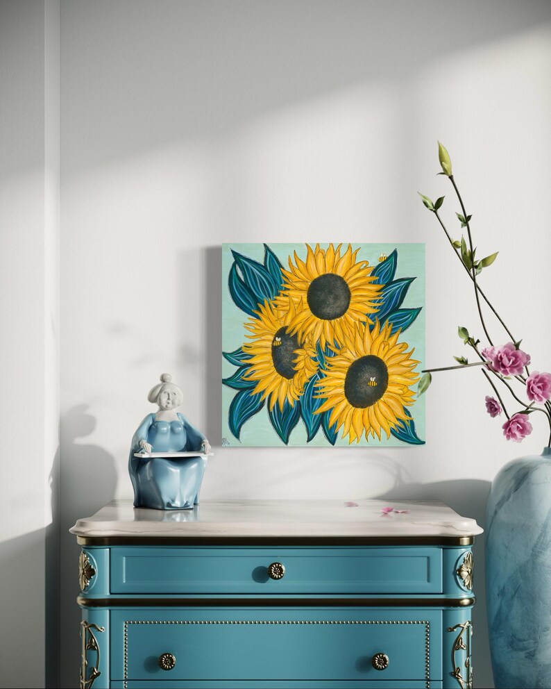 May include: A painting depicting three sunflowers with dark centres and yellow petals set against a light blue background. The sunflowers are surrounded by dark green leaves.