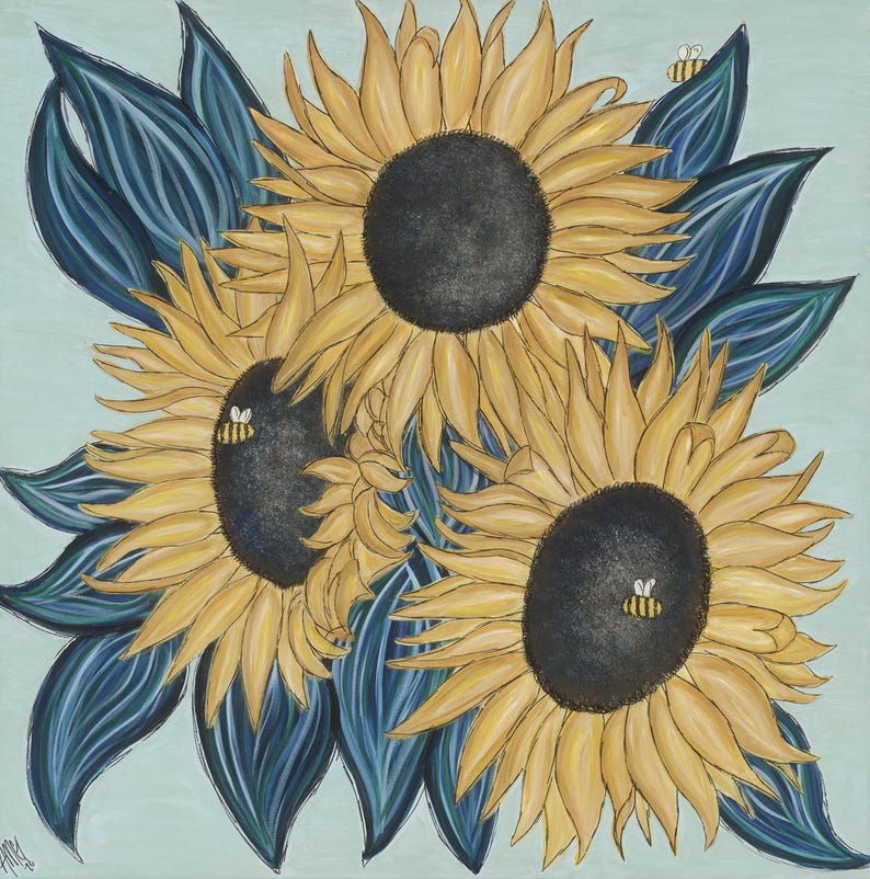 May include: Three yellow sunflowers with dark centres are arranged in a bouquet with blue-green leaves. Two small bees are perched on the sunflowers.