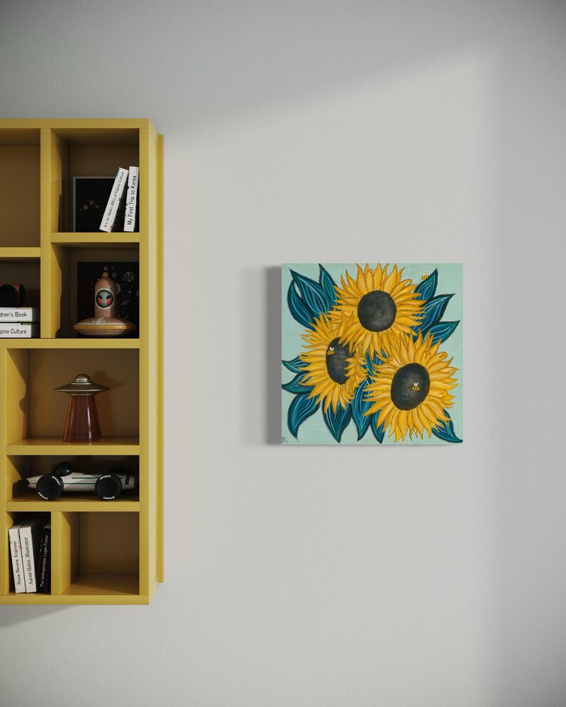 May include: A painting of three sunflowers with yellow petals and dark brown centres. The sunflowers are surrounded by dark blue leaves on a light blue background.