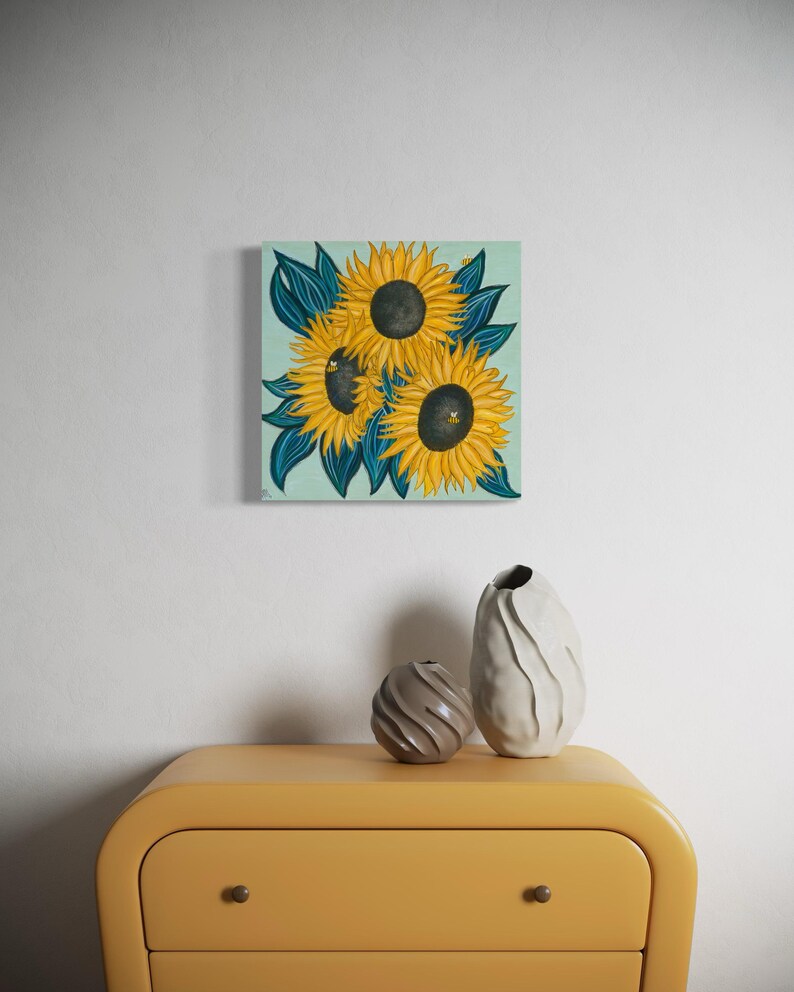 May include: A painting of three sunflowers with dark green leaves on a light blue background.
