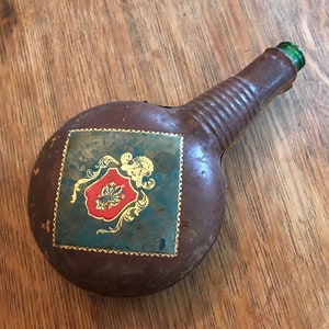 Decantador de vino o licor vintage envuelto en cuero