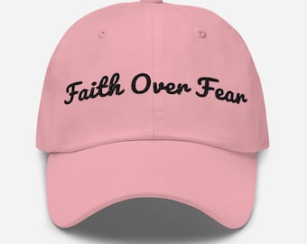 Puede incluir: Una gorra de béisbol rosa con el texto "Faith Over Fear" bordado en negro.
