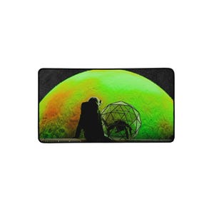 May include: A rectangular desk mat featuring a graphic illustration of a silhouetted astronaut sitting before a large, glowing green planet. Beside the astronaut is a geometric wireframe sphere containing a dark, multi-legged creature silhouette.