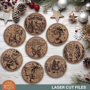 Puede incluir: Un conjunto de posavasos de madera cortados con láser con diseños temáticos de Grinch. Cada posavasos presenta una ilustración diferente del personaje de Grinch y texto, incluyendo "Merry Grinchmas" y "Whoville". Los posavasos son redondos y de madera clara.