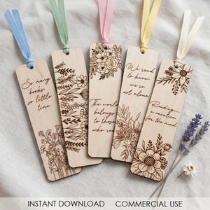 Könnte beinhalten: Fünf Holz-Lesezeichen mit floralen Designs und inspirierenden Zitaten. Jedes Lesezeichen hat ein farbiges Band. Die Zitate lauten unter anderem: "So many books, so little time" und "The world belongs to those who read."