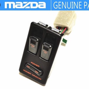 May include: Black power window switch with two "PULL UP" buttons and an "ON/OFF" switch. The switch is labeled "POWER" and "POWER WINDOW" in orange text. A white connector with wires is attached.