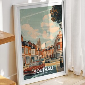 May include: A white framed poster with a vintage illustration of a street scene in Southall, England. The poster features a red car, buildings, and a church in the background.