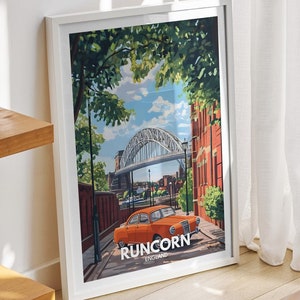 Può includere: Una stampa artistica incorniciata con un design di poster di viaggio vintage con la parola "RUNCORN". L'opera d'arte raffigura un ponte, un'auto arancione e degli edifici. La stampa è su un tavolo di legno vicino a una finestra con tende bianche.