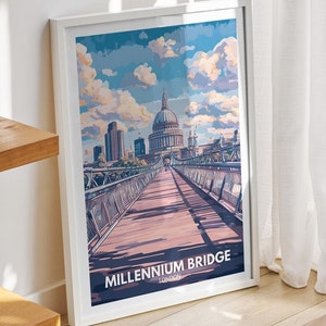Puede incluir: Una impresión enmarcada en blanco de una ilustración colorida del Puente del Milenio en Londres, Inglaterra. El puente es un puente peatonal que cruza el río Támesis. La impresión está colgada en una pared en una habitación con un estante de madera y un taburete de mimbre.