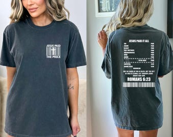 Könnte beinhalten: Ein schwarzes T-Shirt mit einem weißen Grafikdruck eines Barcodes mit einem Kreuz und dem Text "Jesus Paid The Price". Die Rückseite des Shirts hat einen weißen Grafikdruck eines Belegs mit dem Text "Jesus Paid It All" und einer Liste von Artikeln mit dem Preis "Paid" neben jedem Artikel. Der Beleg enthält auch den Text "Römer 6:23".