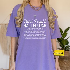 a woman wearing a purple shirt with a cross on it