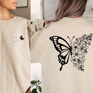 a woman wearing a sweatshirt with a butterfly on it