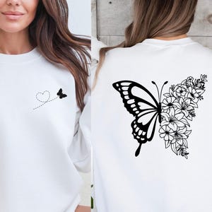 a woman wearing a white sweatshirt with a butterfly on it