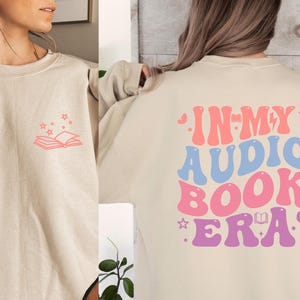 a woman wearing an in my audio book era sweatshirt