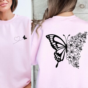 a woman wearing a pink shirt with a butterfly and flowers on it