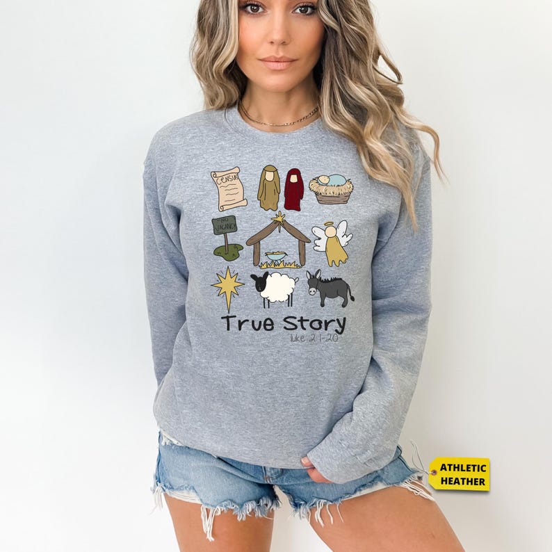 a woman wearing a grey sweater with a graphic of a dog, sheep, and