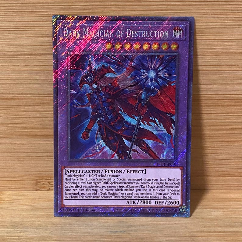 Peut inclure: Carte &agrave; collectionner holographique avec un bord violet, repr&eacute;sentant le personnage "Dark Magician of Destruction". L'illustration montre un sorcier en rouge fonc&eacute; et bleu. Le texte d&eacute;taille les m&eacute;caniques de jeu et les statistiques.