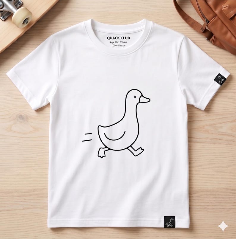 May include: White t-shirt with a black outline drawing of a running duck. The shirt has the text "QUACK CLUB" and "Age 10-12 Years 100% Cotton" printed on the front. A small duck logo is on the sleeve.