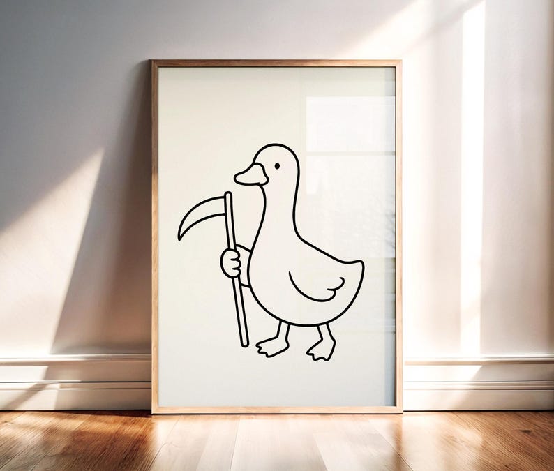 May include: A framed wall art print featuring a simple black line drawing of a duck standing upright and holding a scythe. The illustration is centered on a plain off-white background, enclosed within a light-toned wooden frame.