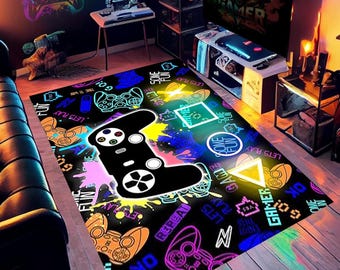 May include: A black and neon-colored gamer rug with a large black video game controller in the center. The rug has a variety of neon-colored text and graphics, including "Let's Play", "Some Fun", and "Gamer".