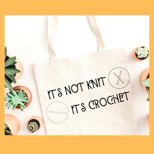 May include: White tote bag with black text that reads "It's not knit, it's crochet". The text is surrounded by two icons, one of knitting needles and one of a crochet hook.