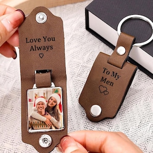 May include: Brown leather keychain with a photo insert and a message that says "Love You Always" on one side and "To My Men" on the other side. The keychain has a silver metal ring.