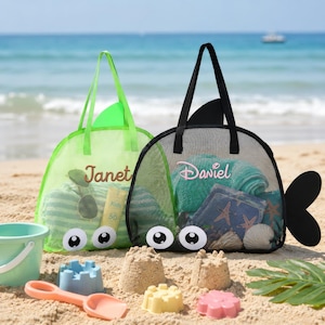 May include: Two mesh tote bags shaped like fish, one lime green with the name Janet and one black with the name Daviel. Both bags feature large cartoon eyes, a dorsal fin, and a tail. The bags are filled with beach towels and accessories.