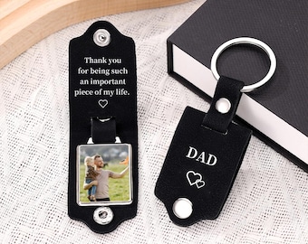 May include: Black leather keychain with a photo frame and the text "Thank you for being such an important piece of my life." The keychain also has a smaller black leather tag with the word "DAD" and two hearts.