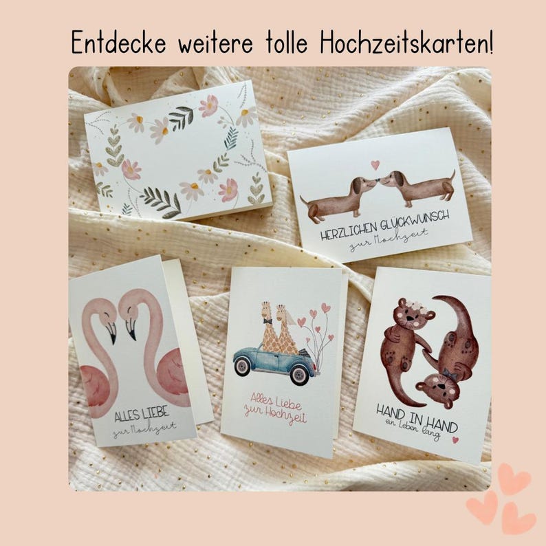 May include: A collection of greeting cards with various illustrations. Designs include floral arrangements, dachshunds, flamingos, giraffes in a car, and otters. Text on the cards includes phrases like "Alles Liebe zur Hochzeit" and "Hand in Hand an Leben lang."