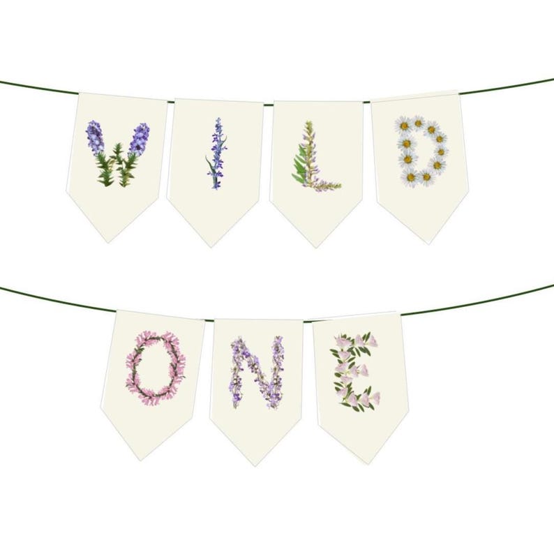 May include: A banner with the words "WILD ONE" spelled out on cream-colored pennants. Each letter is formed with floral arrangements in shades of purple, pink, and white, strung on a green string.