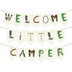 K&ouml;nnte beinhalten: Ein Banner mit der Aufschrift "WELCOME LITTLE CAMPER" auf einzelnen Wimpeln. Die Buchstaben bestehen aus verschiedenen nat&uuml;rlichen Elementen, darunter Federn, Moos und Zweige, vor einem cremefarbenen Hintergrund. Das Banner ist an einer d&uuml;nnen schwarzen Schnur befestigt.