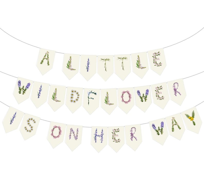 May include: A banner with three rows of pennants spelling out "A LITTLE WILDFLOWER IS ON HER WAY." Each letter is decorated with floral designs in various colors, including purple, green, and pink. The pennants are cream-colored and strung on a thin white string.