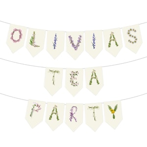 A floral banner with the words 'Olivia's Tea Party' spelled out using wildfowers. The O is with pink obedient flowers, the L with licorice flowers, I with sage, V with purple violets, R with redbuds and Y with yellow yarrow. The banner is made of a very light cream paper and there is a string running through the top. The letters are on individual rectangular papers with pointed tips. It has a rustic, cottage garden boho vibe.