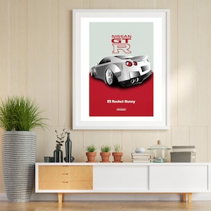 Puede incluir: Un Nissan GT-R blanco con detalles rojos y el texto "NISSAN GT-R" y "F1 Rocket Bunny" sobre un fondo rojo. El coche es una versi&oacute;n modificada del Nissan GT-R.