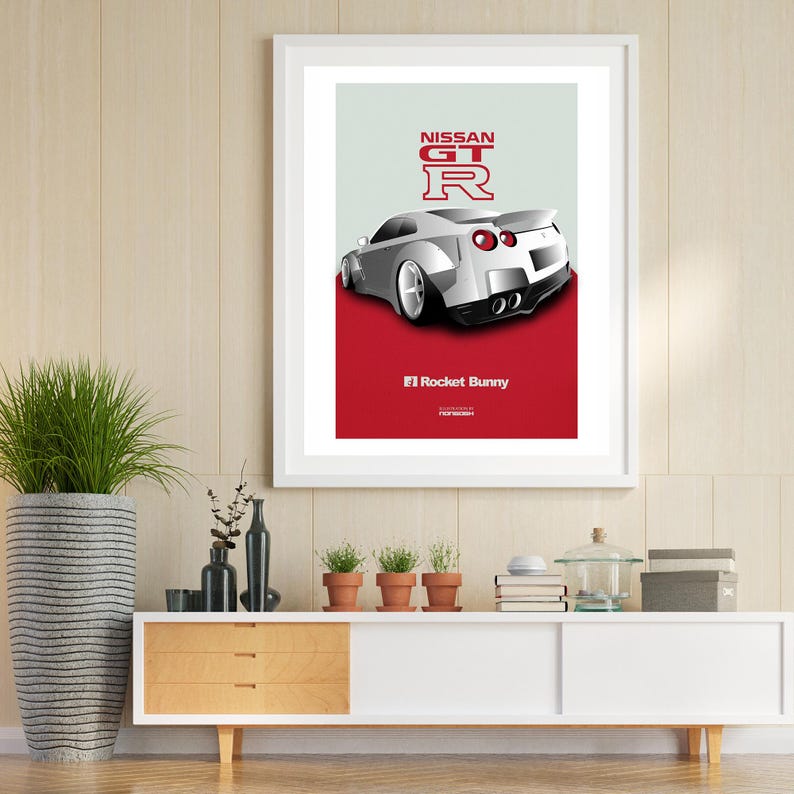 Puede incluir: Un Nissan GT-R blanco con detalles rojos y el texto "NISSAN GT-R" y "F1 Rocket Bunny" sobre un fondo rojo. El coche es una versi&oacute;n modificada del Nissan GT-R.