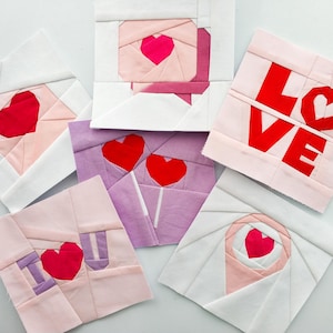 May include: Six handmade fabric squares with a Valentine's Day theme. Each square features a different design with hearts, the word "LOVE", and the words "I LOVE YOU".