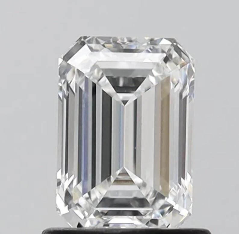 May include: A clear emerald cut diamond with a brilliant shine.